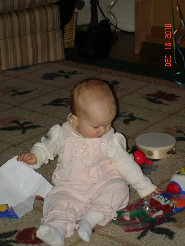 She is getting the knack of opening presents!  Note the Christmas stocking completed by G. just in time!