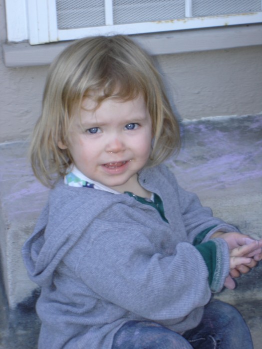 Mathilda drawing with chalk on the patio.