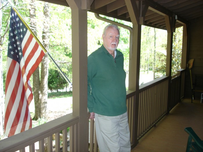 Brother Dave on the porch of their house in the woods.